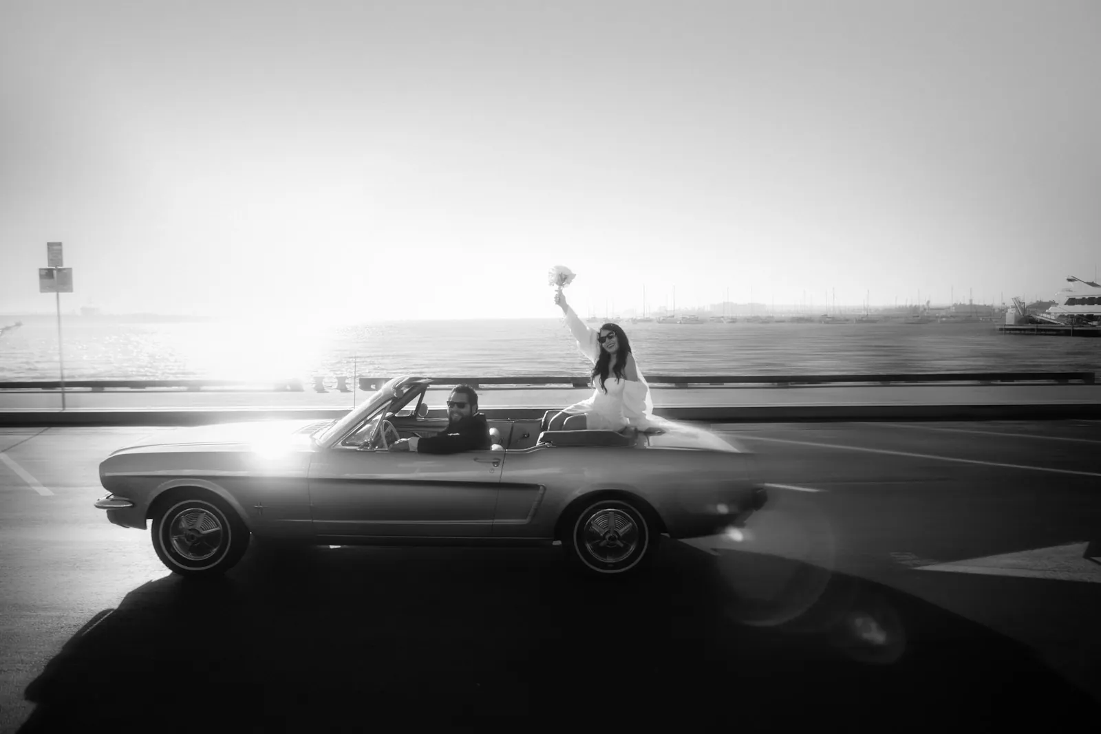 Bride and groom riding in a convertible
