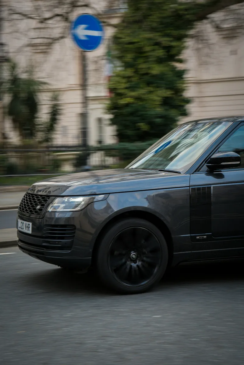 Black Range Rover driving through a city street
